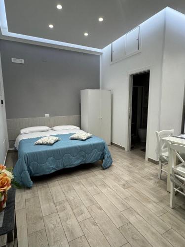 ein Schlafzimmer mit einem Bett mit blauer Bettdecke in der Unterkunft Aleila in Bacoli