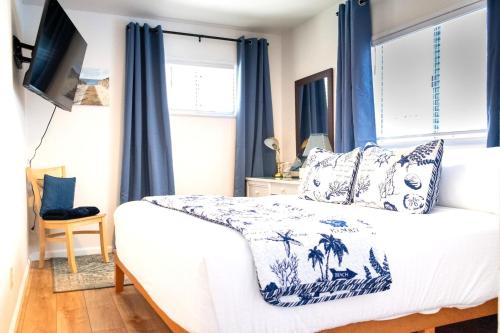 a bedroom with a bed with blue curtains at Cambria Mountain View Retreat in Cambria
