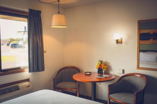 a room with a small table and chairs and a window at Forrest Inn in Amery