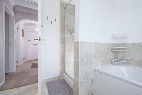 a white bathroom with a tub and a shower at The Willows Dinas Cross in Newport