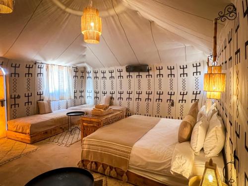 a bedroom with two beds in a tent at dreaming desert Luxury Camp in Adrouine