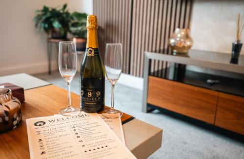 a bottle of champagne and two wine glasses on a table at Cozy 1BR Seaside Apt in Brighton Marina Village in Brighton & Hove