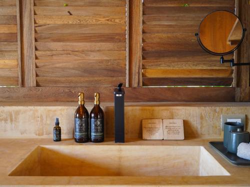 two bottles of wine sitting on a kitchen sink at Kymaia Hotel Puerto Escondido in Tlachicón