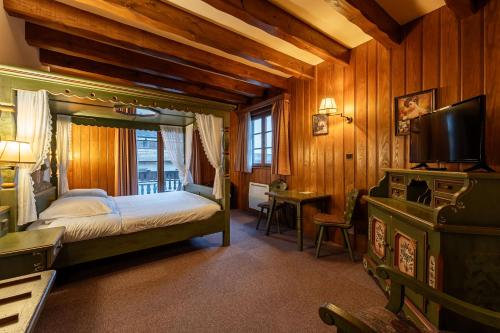 Scharrachbergheim IrmstettにあるHotel et Spa du Scharrachのベッドとテレビのある寝室