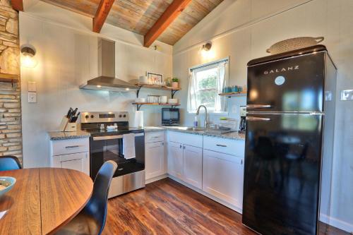 a kitchen with a black refrigerator and a table at Millies Cottages Unit 5 - Josephine in Canyon Lake