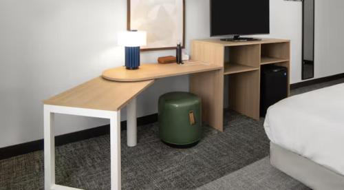a bedroom with a desk and a bed and a desk with a computer at Spark by Hilton Charlotte Airport North in Charlotte