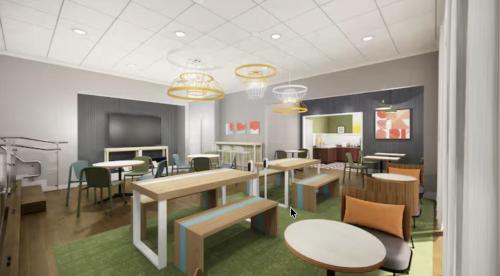 a dining room with tables and chairs in a room at Spark by Hilton Charlotte Airport North in Charlotte