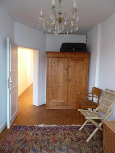 a living room with a chair and a chandelier at Vorderer Westen Kassel in Kassel