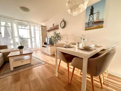 a living room with a table and chairs in a room at Ferienwohnung De Diek 103 in Dorum-Neufeld