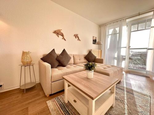 a living room with a couch and a table at Ferienwohnung De Diek 103 in Dorum-Neufeld