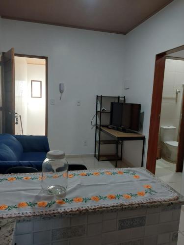 a room with a bed with a table with flowers on it at Bem Estar no Bom Ap 2 in Arapiraca