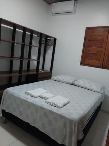 a bedroom with a bed with two towels on it at Bem Estar no Bom Ap 2 in Arapiraca