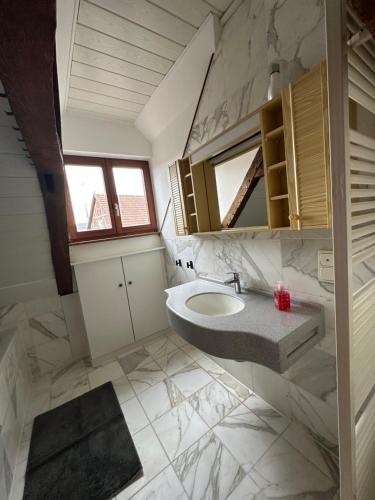 a bathroom with a sink and a mirror at Good N8 Apartment in Wabern