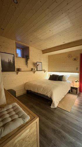 a bedroom with a large bed in a wooden room at Le petit chalet de Cholet in Cholet