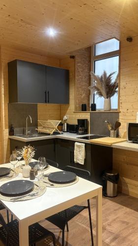 a kitchen with a white table with chairs and a sink at Le petit chalet de Cholet in Cholet