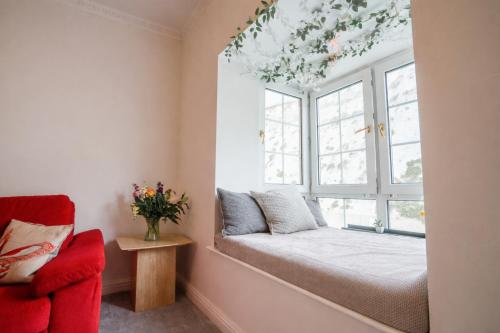 a window seat in a room with a red chair at Cozy 1BR Seaside Apt in Brighton Marina Village in Brighton & Hove