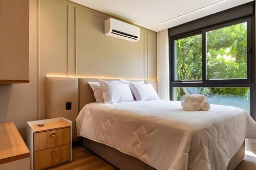 a bedroom with a bed with a teddy bear on it at 2-suite apartment just a few meters from Rua Coberta. in Gramado