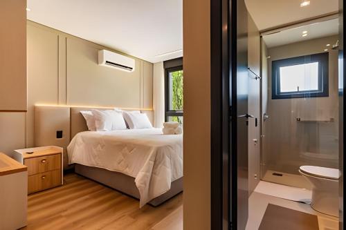 a bedroom with a bed and a bathroom with a toilet at 2-suite apartment just a few meters from Rua Coberta. in Gramado