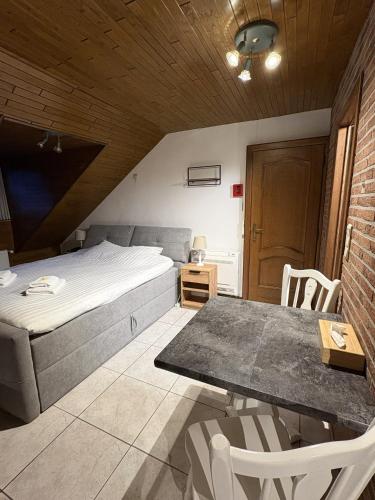 ein Schlafzimmer mit einem Bett, einem Tisch und Stühlen in der Unterkunft Hotel Monika in Zutendaal