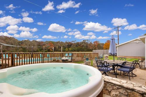 a hot tub on a patio with a table and chairs at Arrowhead Falls in Wimberley