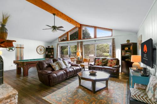 a living room with couches and a pool table at Arrowhead Falls in Wimberley