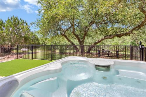 a hot tub in a yard with a tree at Artista in Wimberley