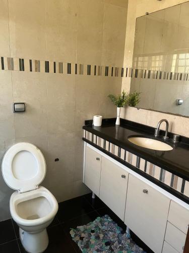 a bathroom with a toilet and a sink at Pousada Vermont in Maringá