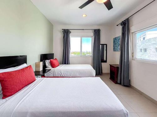 a bedroom with two beds and a window at Isla Condo Puerta al Mar 403 at Sac Bajo in Isla Mujeres