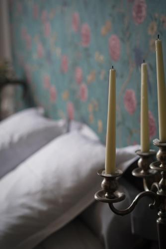 a group of three candles sitting next to a bed at La Maison Saint Aignan in Saint-Aignan