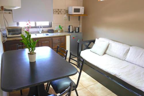 プエルトイグアスにあるZUHAUSEのテーブルとソファとキッチンのあるリビングルーム