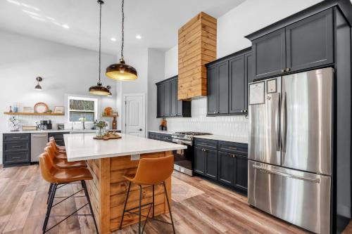 a kitchen with black cabinets and a stainless steel refrigerator at Barndo on the Blanco in Wimberley