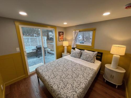 a bedroom with a bed and a sliding glass door at Wally’s Matchbox |New|Hot Tub|Fire Pit|Close 2 All in Hawley