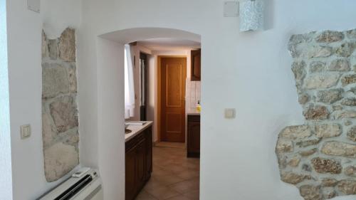 a view of a kitchen with a stone wall at Apartman Karla in Mostar