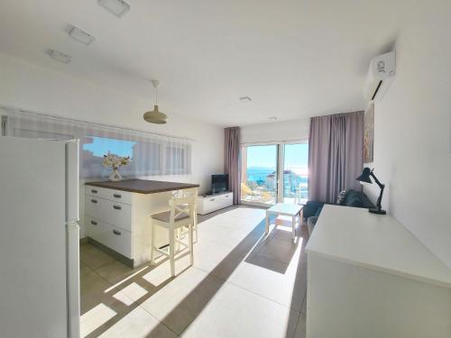 a white kitchen with a desk and a table at Villa Ilenia in Murter