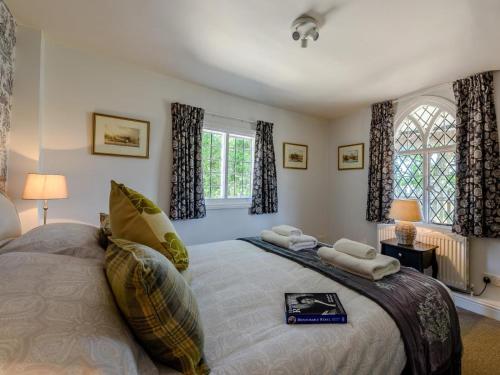 a bedroom with a large bed and two windows at 1 Bed in Brockenhurst oc-78767 in Beaulieu