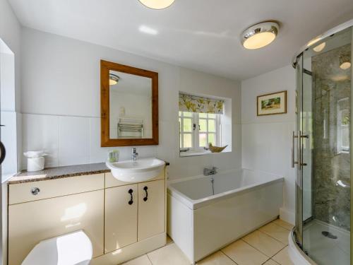 a bathroom with a tub and a sink and a shower at 1 Bed in Brockenhurst oc-78767 in Beaulieu