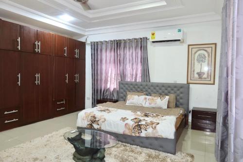 una camera da letto con un letto e un tavolo di vetro di Lebon Paradise a Accra