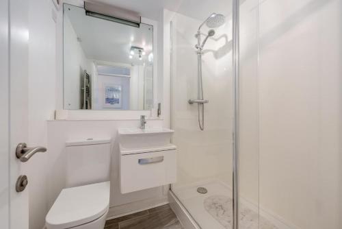 a white bathroom with a shower and a sink at 2 Bed in Woolacombe oc-bsnug in Woolacombe