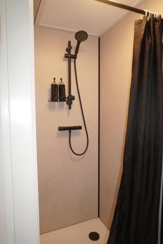 a shower in a bathroom with a shower curtain at Next To Sea in Vlissingen
