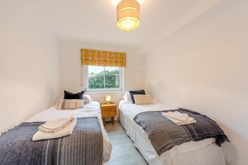 two twin beds in a room with a window at 2 Bed in Woolacombe oc-bsnug in Woolacombe