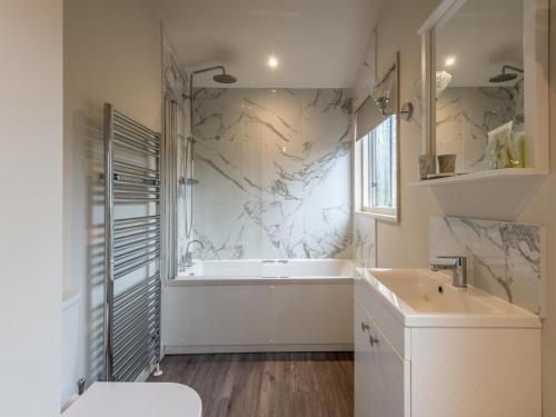 a bathroom with a white tub and a sink at 1 Bed in Brockenhurst oc-78005 in Beaulieu