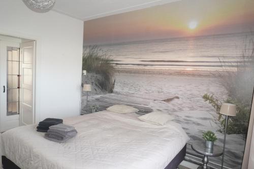 a bedroom with a bed in front of a beach at Next To Sea in Vlissingen
