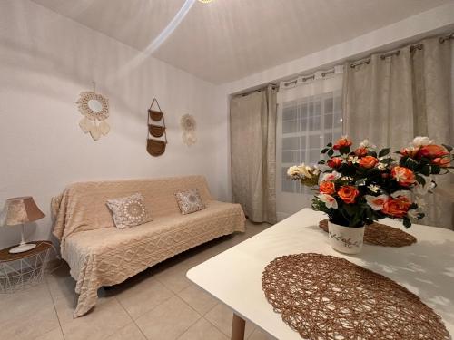 a living room with a couch and a table with a vase of flowers at Apartamentos Amy 3 con vista a mar in Palos de la Frontera
