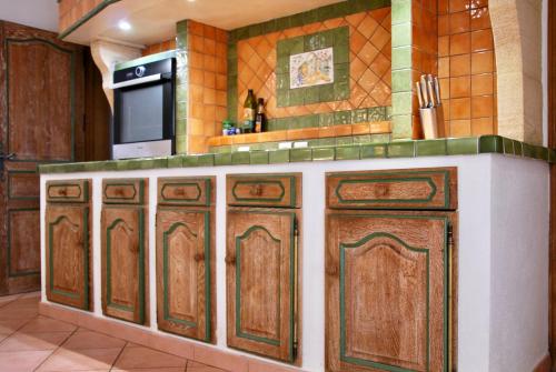a kitchen with wooden cabinets and a microwave at Villa A Macchia, piscine et vue sur Bonifacio in Bonifacio
