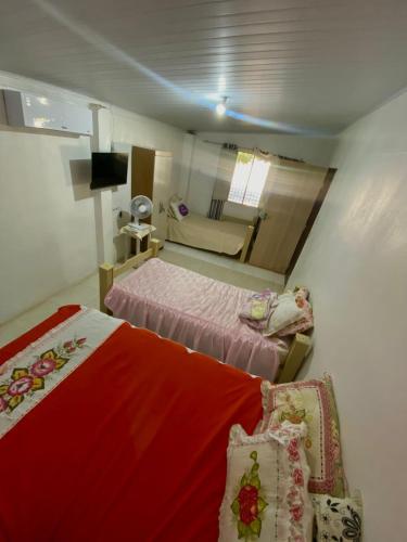 a small bedroom with two beds and a couch at Chácara Jacinto Alves in Paulo Afonso