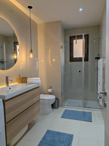 a bathroom with a shower and a sink and a toilet at Harba - An Escape at Fort Chambray in Għajnsielem
