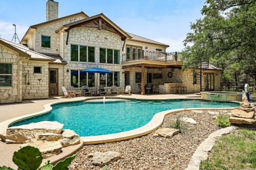 a house with a swimming pool in front of a house at Big Red Chicken Estate in Wimberley