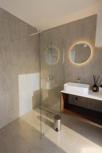 a bathroom with a sink and a glass shower at Solmare Neum Apartmani in Neum