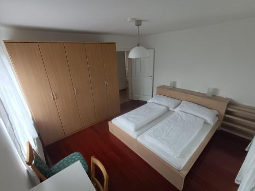 a bedroom with a large bed and wooden cabinets at Große Ferienwohnung im Rosental ideal für 4 bis 6 Personen mit Balkon und Garten in Maria Elend