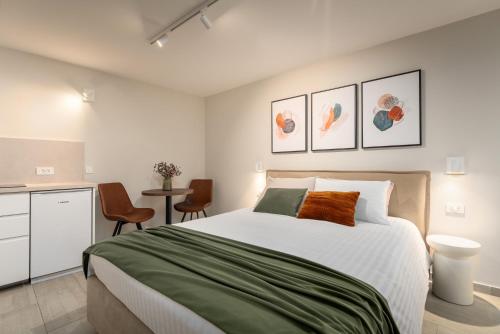 a bedroom with a bed and a table and chairs at Degrassi Square Apartments in Vrsar